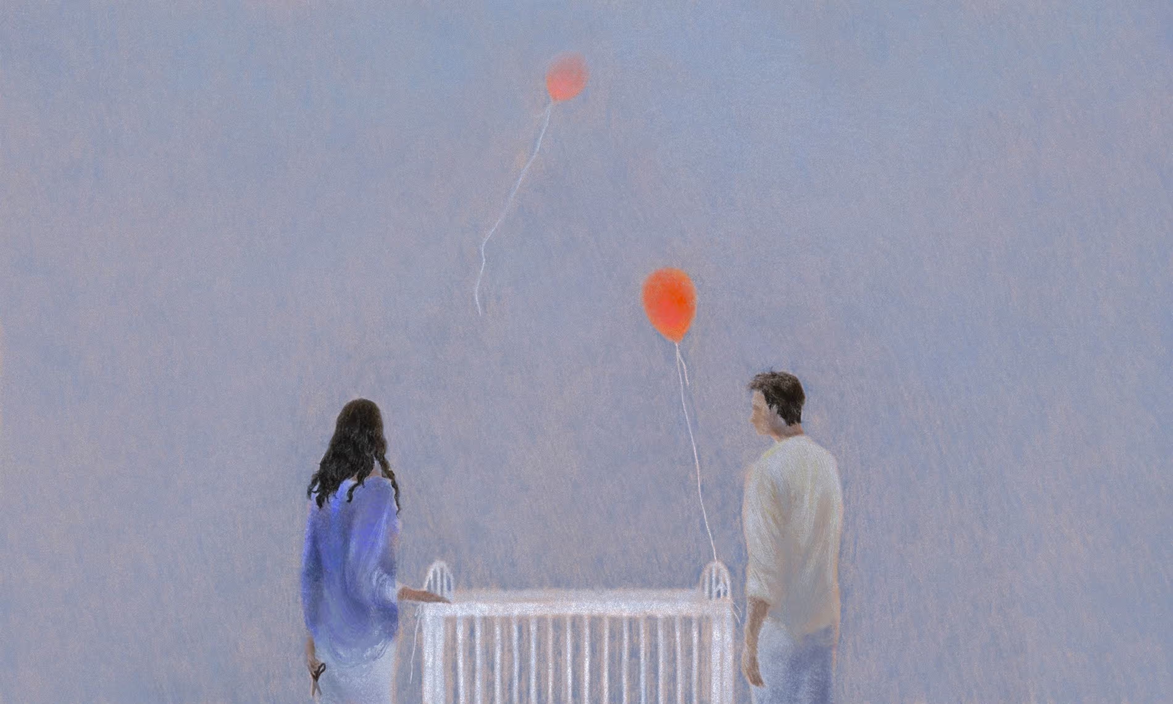 A couple stands next to an empty crib while balloons float up into the air.